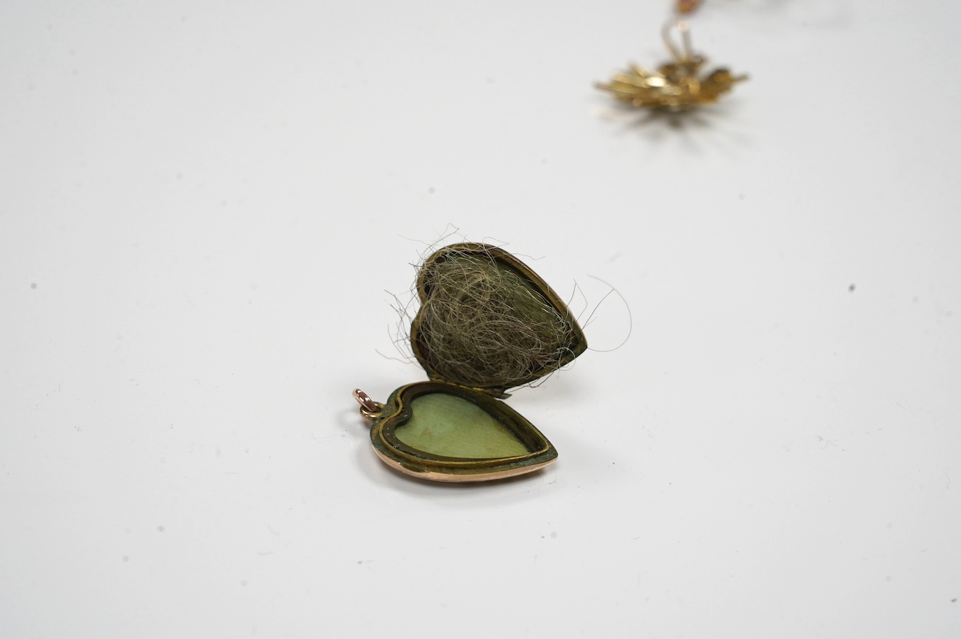 Five assorted gem set pendants including a 9ct and seed pearl star, 20mm, a yellow metal and amethyst set drop, a yellow metal and white opal and an Edwardian yellow metal heart shaped locket. Condition - fair